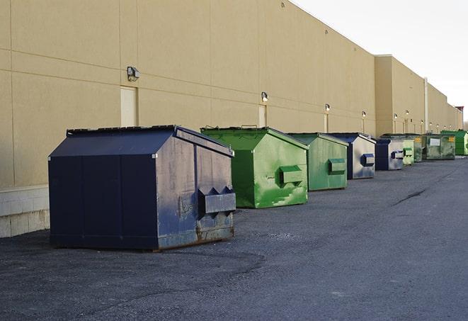 a row of construction dumpsters parked on a jobsite in Dinuba